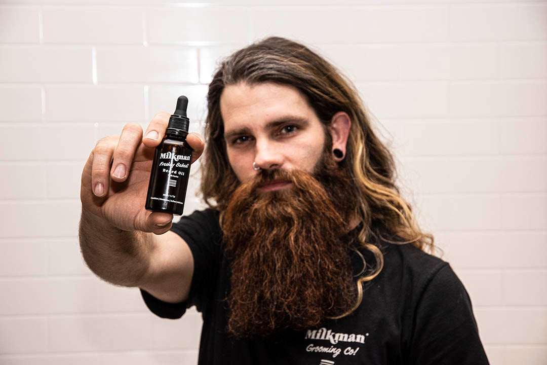 bearded man holding milkman freshly baked beard oil
