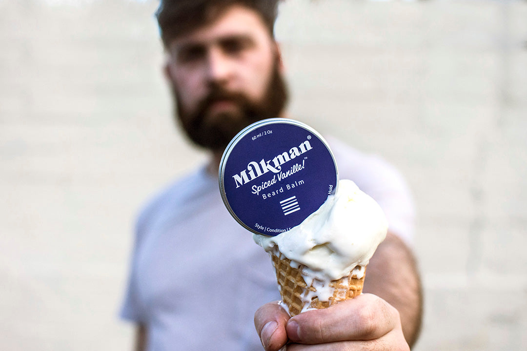 bearded man holding milkman grooming co beard balm
